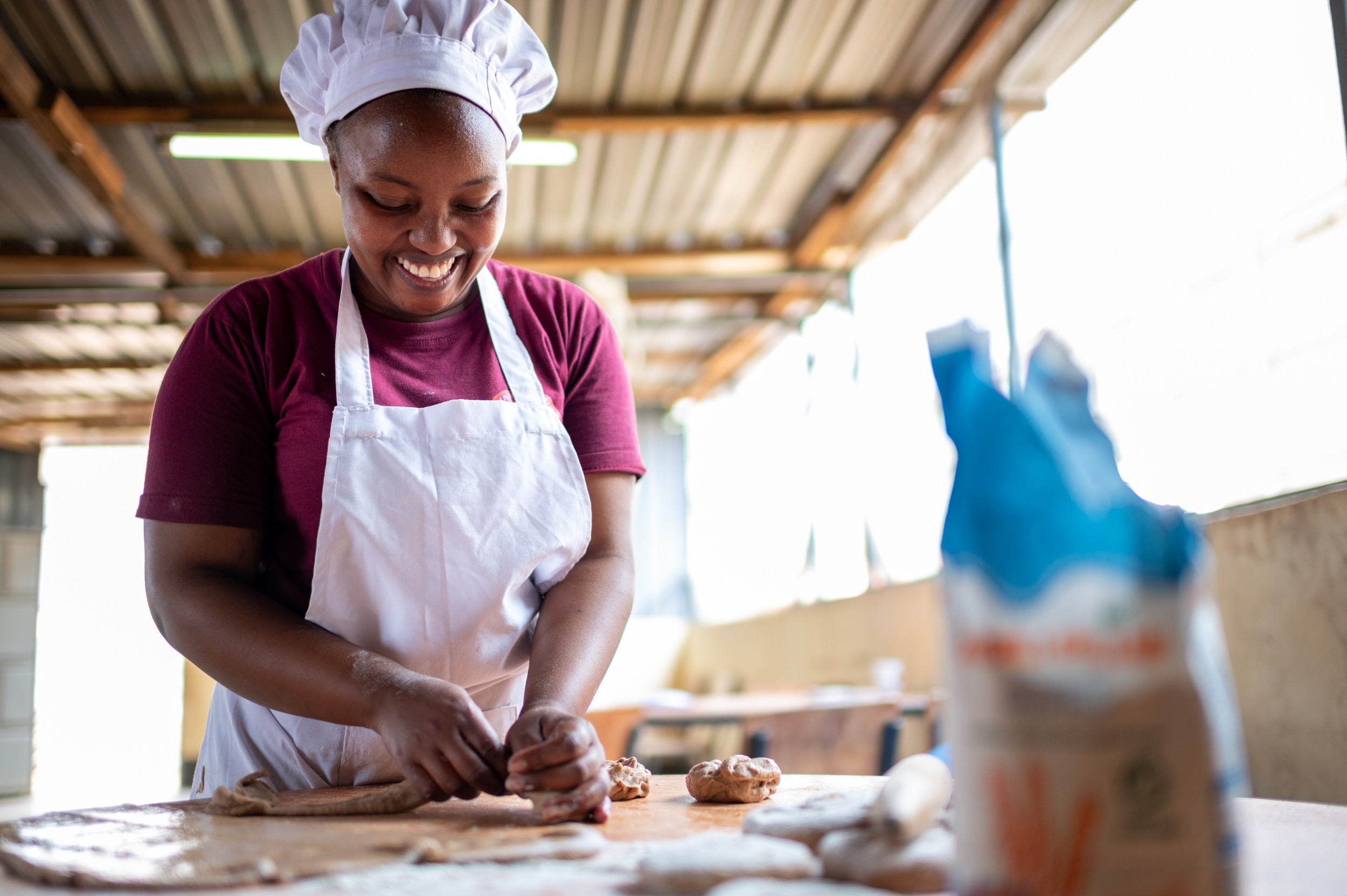 woman smiling and preparing chapati